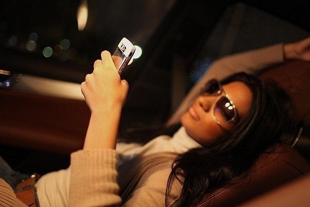 девушка с мобильником в салоне машины