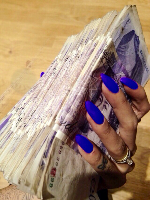 Деньги в руке с синим лаком на ногтях