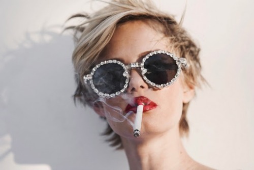 Девушка с сигаретой и в очках со стразами на оправ