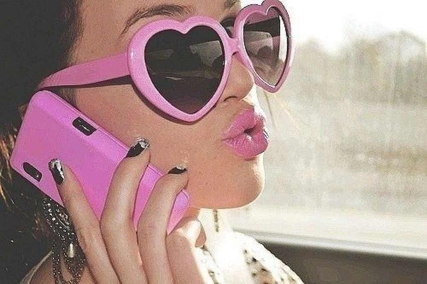 в очках с розовой оправой разговаривает по мобиле