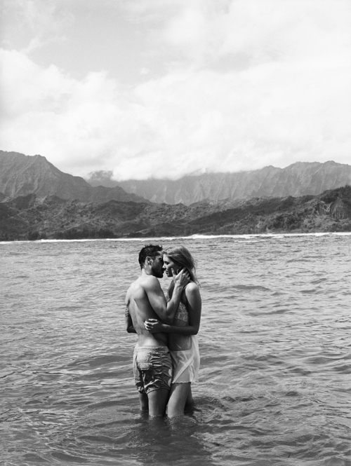 Парень с девушкой целуются, стоя в море