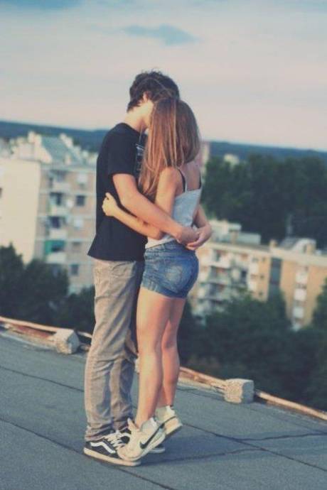 Парень с девушкой целуются на крыше дома