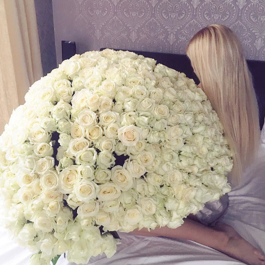 Огромный букет белых роз, подаренный девушке