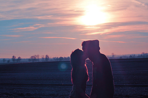 Двое целуются на закате солнца