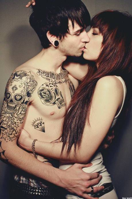 Парень с татуировкой черепа на руке целует девушку