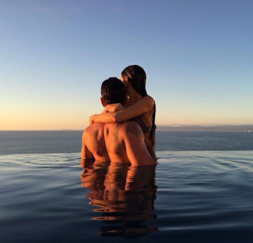 Парень с девушкой обнимаются в море