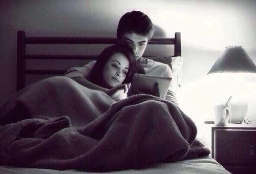 Парень и девушка с планшетом в кровати