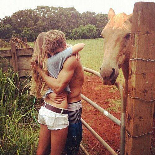 Обнимающиеся парень с девушкой и рыжая лошадь
