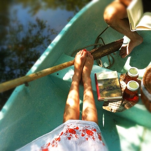 Парень и девушка в лодке с едой и книгой