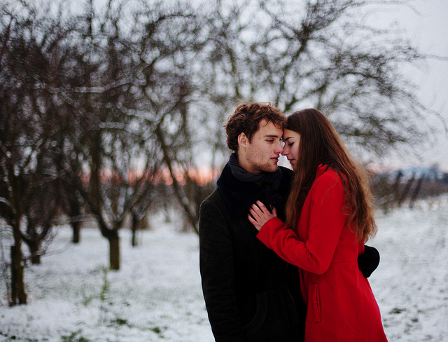 Девушка в красном пальто рядом с любимым парнем