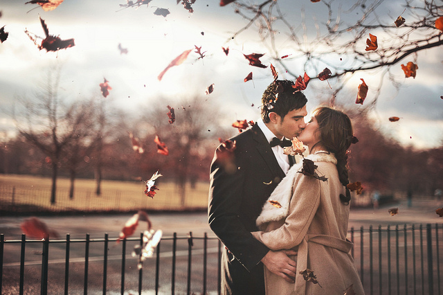 Осенний поцелуй на фоне летящих листьев