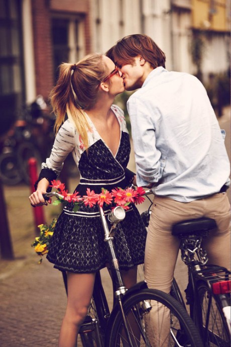 Парень и девушка целуются на велосипедах