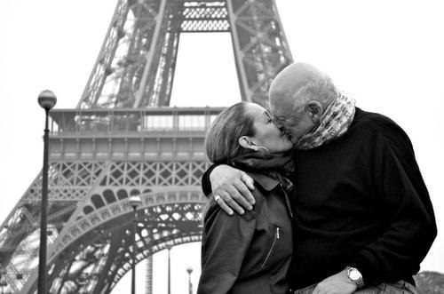 пожилая пара целуются на фоне Эйфелевой башни