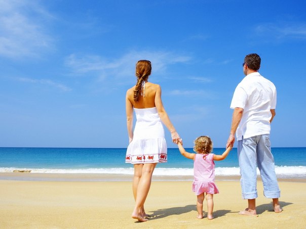Семья у моря: мама, папа и маленькая дочка