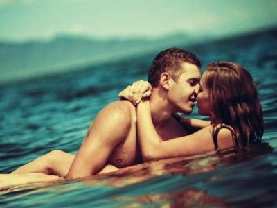 Парень с девушкой целуются в море