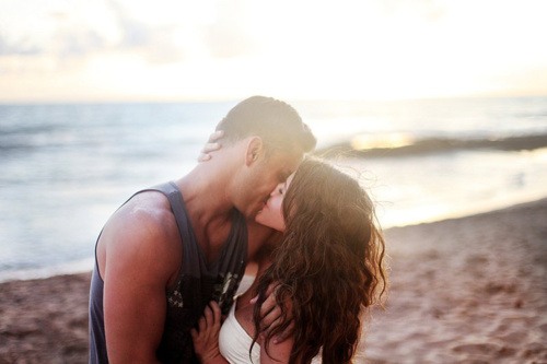 Красивые парень и девушка целуются у моря