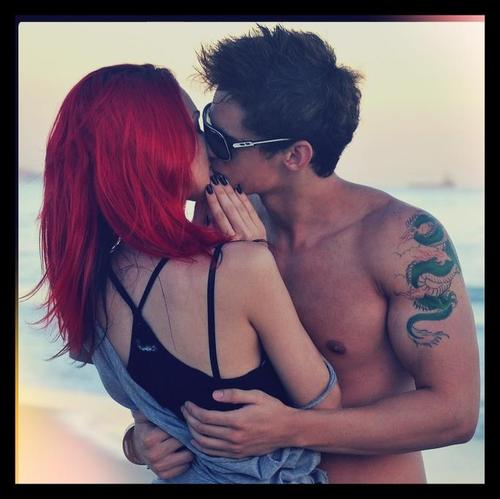 Парень с татуировкой дракона целует девушку