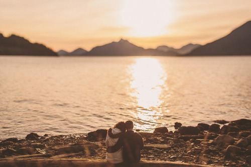 Парень и девушка, обнявшись любуются закатом