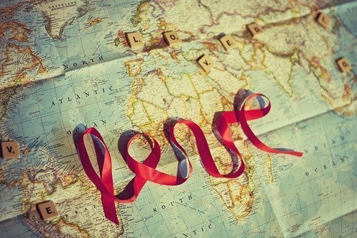 надпись LOVE из красной ленточки на карте мира