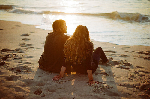 Парень и девушка, сидящие на берегу моря